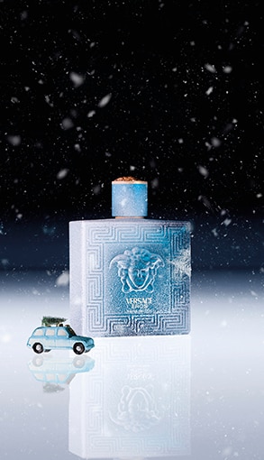 Versace Eros férfi parfüm kék üvegben, téli hóesésben – luxus illat online vásárláshoz.